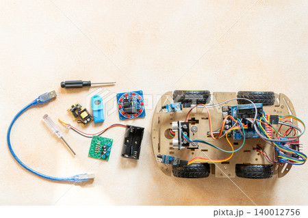 DIY Robot Car Assembly and Components top view. Educational electronics project for STEM learning and robotics 140012756