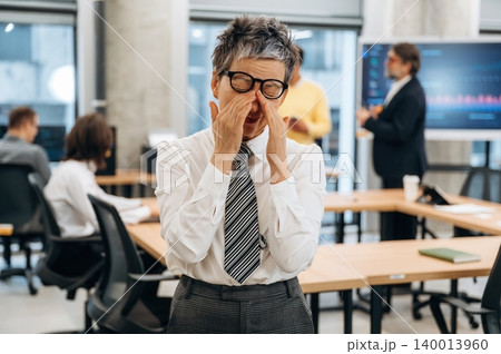 Businesswoman expressing frustration in modern office environment, surrounded by colleagues engaged in discussions and presentations, capturing workplace dynamics and emotions Businesswoman expressing frustration in modern office environment, surrounded by colleagues engaged in discussions and presentations, capturing workplace dynamics and emotions 140013960