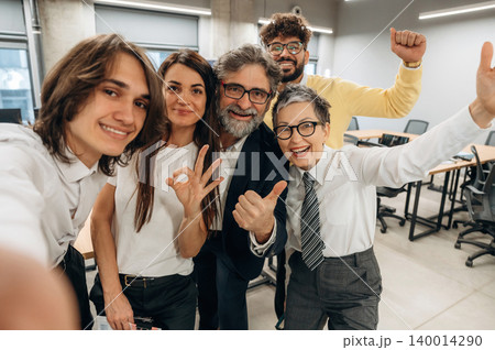Group of diverse business professionals smiling and posing for a selfie in a modern office environment, showcasing teamwork and collaboration in a vibrant workspace Group of diverse business professionals smiling and posing for a selfie in a modern office environment, showcasing teamwork and collaboration in a vibrant workspace 140014290