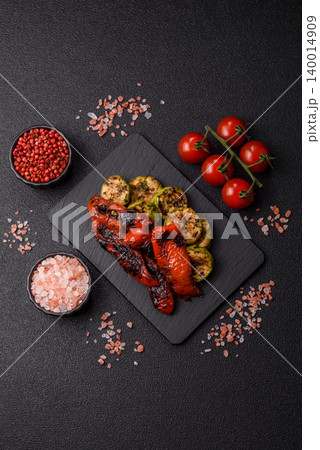 Grilled or barbecued sweet peppers and zucchini slices with salt. Grilled peppers and zucchini Grilled or barbecued sweet peppers and zucchini slices with salt. Grilled peppers and zucchini 140014909