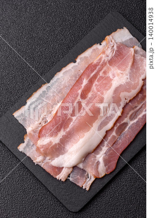 Raw fresh bacon slices with layers of meat or prosciutto with salt and spices. Raw bacon Raw fresh bacon slices with layers of meat or prosciutto with salt and spices. Raw bacon 140014938