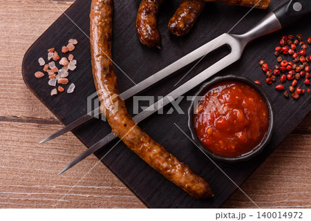 Thin chicken or pork sausages grilled or barbecued. Grilled sausages 140014972