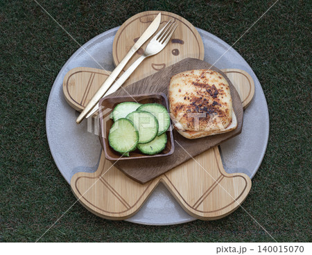 This ensemble elevates the morning ritual into a sensory experience. At its center is an artisanal ham and cheese toastie, charred to a smoky mahogany and bubbling with molten gold. Crisp radish 140015070