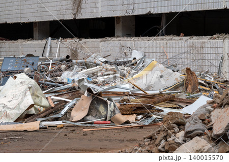 Urban Demolition Debris Pile Outside Abandoned Building Showing Rubble, Metal Pipes and Construction Waste 140015570