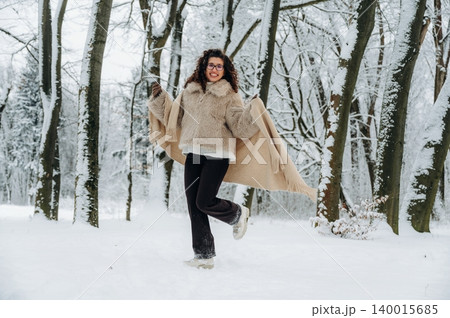 African American woman in cozy fur coat joyfully dancing in snowy forest, surrounded by tall trees and winter landscape, celebrating the beauty of the season African American woman in cozy fur coat joyfully dancing in snowy forest, surrounded by tall trees and winter landscape, celebrating the beauty of the season 140015685
