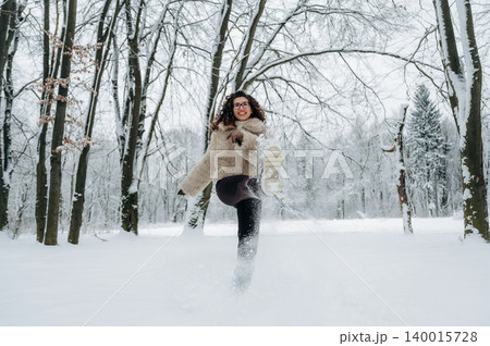 Young woman in a cozy fur jacket joyfully running through a snowy forest, kicking up snowflakes, capturing the essence of winter fun and outdoor adventure Young woman in a cozy fur jacket joyfully running through a snowy forest, kicking up snowflakes, capturing the essence of winter fun and outdoor adventure 140015728