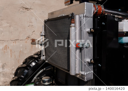 Industrial Radiator Assembly with Metal Pipes and Black Mechanical Frame on Textured Background 140016420