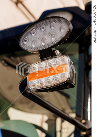 Close up of LED work lights on heavy machinery vehicle with orange reflector in outdoor setting Close up of LED work lights on heavy machinery vehicle with orange reflector in outdoor setting 140016426