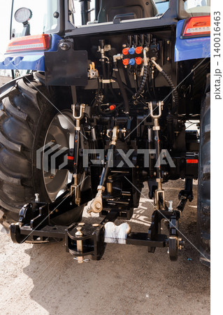 Rear View of Blue Agricultural Tractor with Hydraulic Hitch and Large Black Rubber Tires Rear View of Blue Agricultural Tractor with Hydraulic Hitch and Large Black Rubber Tires 140016463