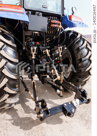 Rear View of Blue Agricultural Tractor with Large Rubber Tires and Three Point Hitch System Rear View of Blue Agricultural Tractor with Large Rubber Tires and Three Point Hitch System 140016497
