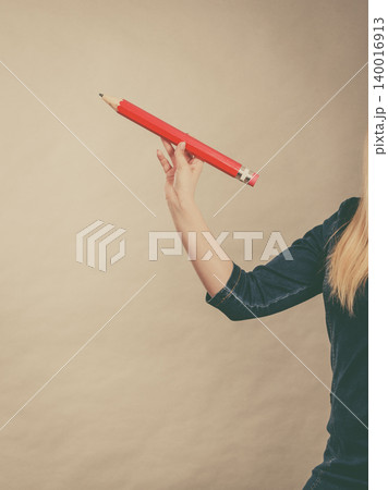 Female hand holds big red pencil Female hand holds big red pencil 140016913