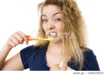 Grumpy tired woman brushing teeth, isolated Grumpy tired woman brushing teeth, isolated 140016939