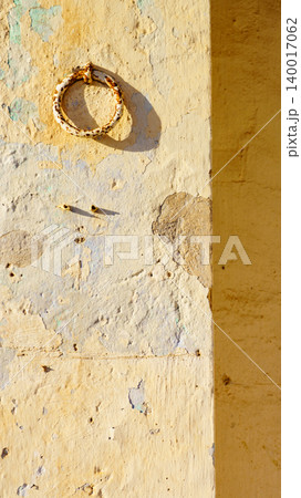 Rusty metal ring mounted on weathered wall 140017062