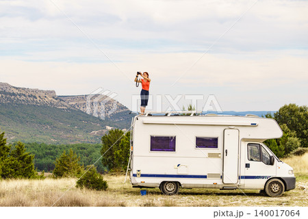 Woman traveling with caravan, taking photo from rv roof 140017064