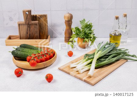 Fresh vegetables and kitchen tools on white counter Fresh vegetables and kitchen tools on white counter 140017125