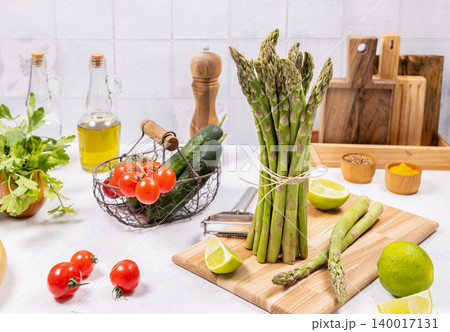 Fresh asparagus bundle and healthy cooking ingredients on kitchen counter 140017131