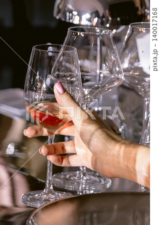 Woman hold wine glass at luxury dinner event with elegant table setting Woman hold wine glass at luxury dinner event with elegant table setting 140017168