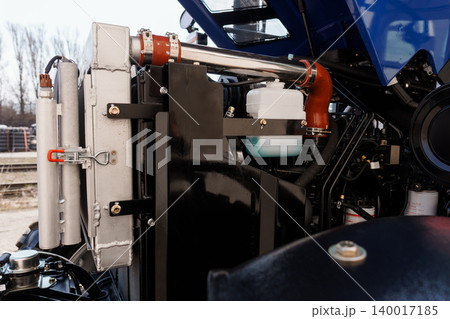 Close up of heavy duty tractor engine components and radiator with blue chassis and metal textures 140017185