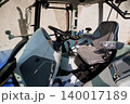 Interior view of modern heavy machinery cabin with driver seat and steering wheel in blue and gray tones 140017189
