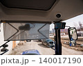 View from Inside a Tractor Cabin Looking Out at a Car and Construction Site in Daylight 140017190