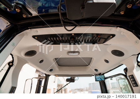 Interior View of Heavy Machinery Cabin with Control Panel and Ceiling Components in White and Black Interior View of Heavy Machinery Cabin with Control Panel and Ceiling Components in White and Black 140017191