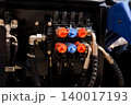 Close up of hydraulic control valve manifold with red and blue caps on heavy machinery equipment 140017193