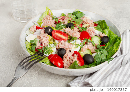 salad with canned tuna, vegetable salad with quail eggs, lettuce and romaine leaves, red onion, cherry tomatoes, olives, keto food, healthy eating, 140017287