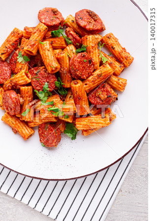rigatoni pasta with spicy sausage, and rich tomato sauce served, on a white plate, homemade, rigatoni pasta with spicy sausage, and rich tomato sauce served, on a white plate, homemade, 140017315