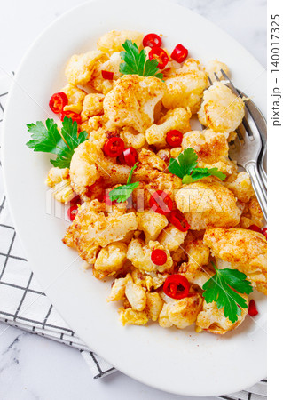 Cauliflower dish, with chili pepper and parsley, on a white plate served on a marble countertop, Cauliflower dish, with chili pepper and parsley, on a white plate served on a marble countertop, 140017325