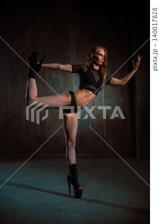 Young sexy woman dancer posing on dark wall background Young sexy woman dancer posing on dark wall background 140017828