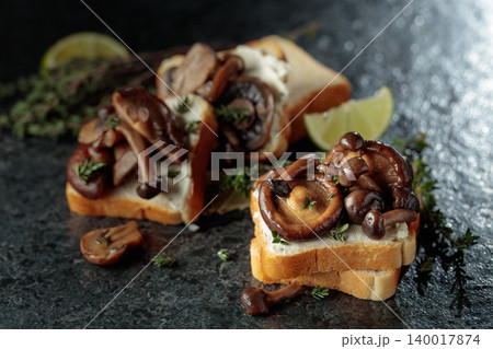 Sandwiches with cream cheese, shiitake and shimeji mushrooms, lime wedges and sprigs of thyme. Sandwiches with cream cheese, shiitake and shimeji mushrooms, lime wedges and sprigs of thyme. 140017874