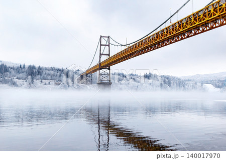 Steel and concrete bridge across the foggy river in winter. Steel and concrete bridge across the foggy river in winter. 140017970