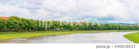 longest linden alley in europe on the Uzh river embankment. lime trees on a sunny summer afternoon. travel destination of transcarpathia. uzhhorod street cityscape beauty. panorama longest linden alley in europe on the Uzh river embankment. lime trees on a sunny summer afternoon. travel destination of transcarpathia. uzhhorod street cityscape beauty. panorama 140018015