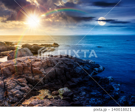 sea coast with stones and rocks. day meet night. summer vacation background at twilight. sun and moon in harmony over seascape with rough terrain. relaxing at the sea. coast of bulgaria wallpaper 140018021