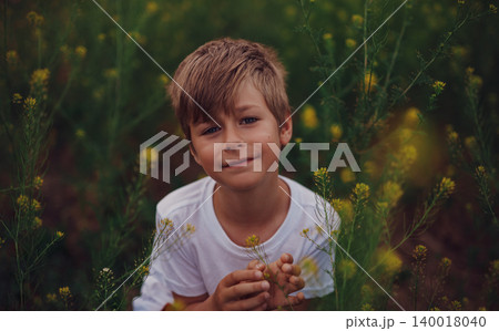Portrait of seven-year-old boy in a flower meadow Portrait of seven-year-old boy in a flower meadow 140018040