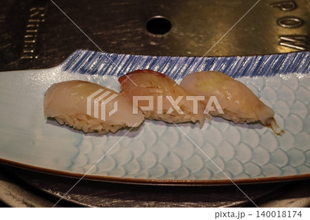 Three Sushi Pieces on Blue Patterned Plate Three Sushi Pieces on Blue Patterned Plate 140018174