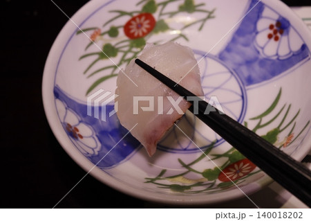 Sushi Piece Held by Chopsticks on Decorative Plate Sushi Piece Held by Chopsticks on Decorative Plate 140018202