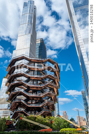 New york, usa august 20,2024. The vessel structure rising against a clear blue sky, surrounded by modern skyscrapers in new york city's hudson yards neighborhood New york, usa august 20,2024. The vessel structure rising against a clear blue sky, surrounded by modern skyscrapers in new york city's hudson yards neighborhood 140018298