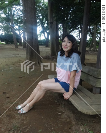 木陰で座る夏服の女性 木陰で座る夏服の女性 140018431