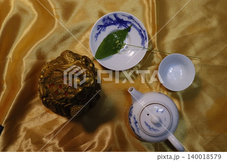 Golden Silk Background with Tea Set and Ornamental Lion Golden Silk Background with Tea Set and Ornamental Lion 140018579