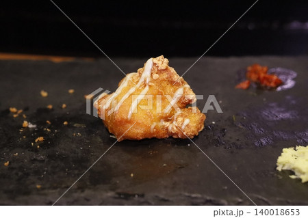Fried Food with White Drizzle on Dark Surface Fried Food with White Drizzle on Dark Surface 140018653