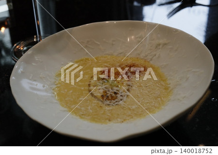 Creamy Soup with Cheese Garnish in White Bowl 140018752