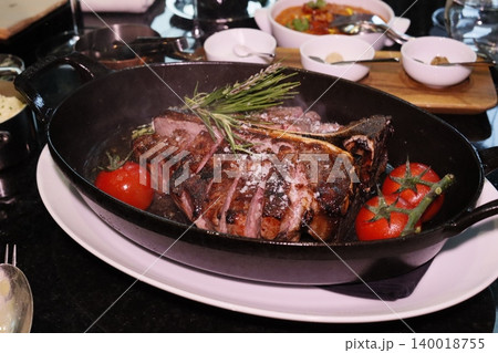 Grilled Steak with Tomatoes and Rosemary in Cast Iron Pan Grilled Steak with Tomatoes and Rosemary in Cast Iron Pan 140018755