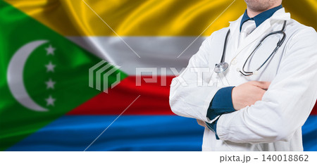 Comoros healthcare concept. Male doctor on Comoros flag. Doctor with crossed arms on Comoros flag 140018862
