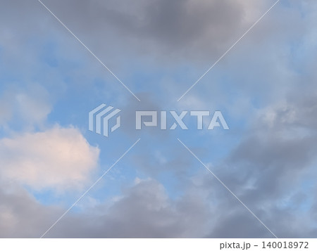 青空とのぞく雲の隙間/天候回復や希望をイメージする空の背景素材 青空とのぞく雲の隙間/天候回復や希望をイメージする空の背景素材 140018972