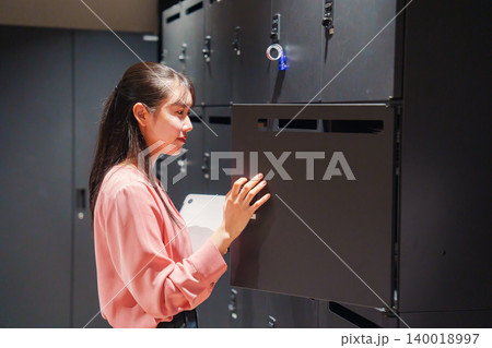 会社のロッカーでPCを保管する女性社員 会社のロッカーでPCを保管する女性社員 140018997