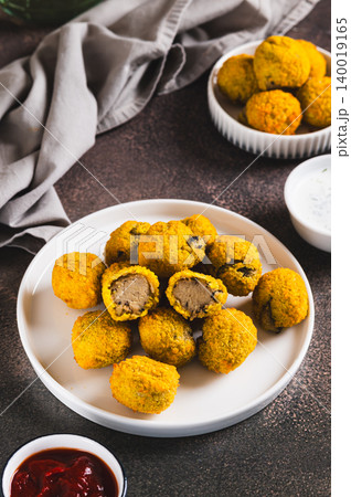 Appetizer potato mushroom balls on a plate and sauces in bowls on the table vertical view Appetizer potato mushroom balls on a plate and sauces in bowls on the table vertical view 140019165