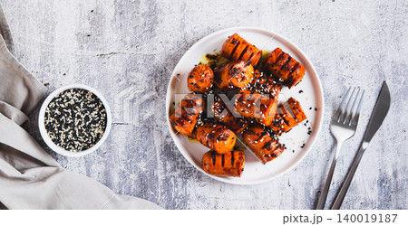 Spicy sausage bites with garlic and sesame seeds on a plate on the table top view web banner Spicy sausage bites with garlic and sesame seeds on a plate on the table top view web banner 140019187