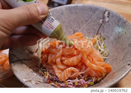 Sauce Drizzled Over Salmon in Bowl with Sprouts 140019762