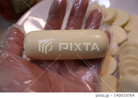 Gloved Hand Holding Cheese with Sliced Cheeses Gloved Hand Holding Cheese with Sliced Cheeses 140019764